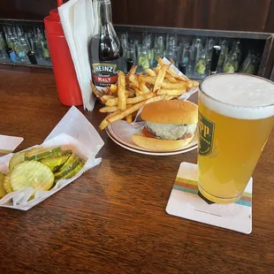 a burger, fries, and beer on a table