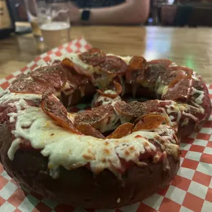 a doughnut covered in pepperoni and cheese
