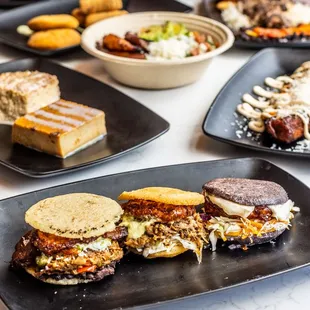 a variety of sandwiches on black plates