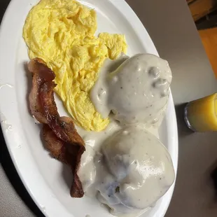 a plate of food with eggs, bacon, and gravy