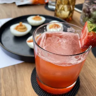 a drink with a strawberry on the rim