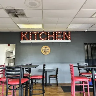 neon sign above tables and chairs