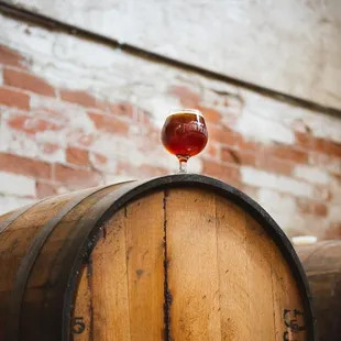 a wine glass on top of a barrel