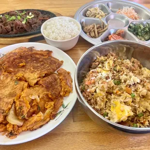 Kimchi pancake, spicy beef bulgogi, chicken fried rice, white rice, and banchan like cabbage kimchi and cucumber kimchi
