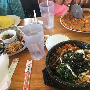 Banchan in the middle, omu rice to far left, kimchi bindedok and dol sot bibimbap