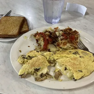 Mushroom and swiss omelette, fried potatoes and wheat toast