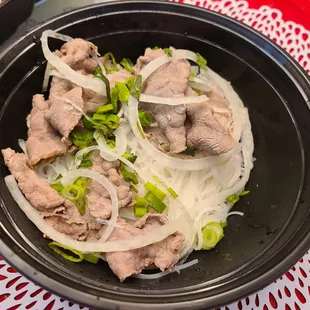 a bowl of noodles with meat and onions