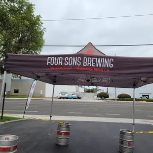 two kegs under a canopy