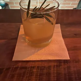 a drink with a sprig of rosemary