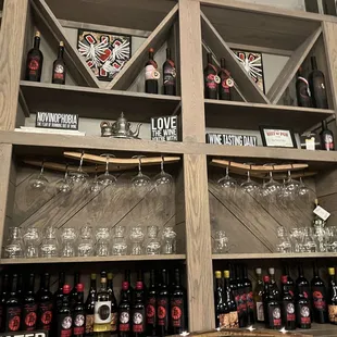 a shelf of wine bottles and glasses