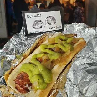 Car wreck a bacon wrapped hotdog wrapped with fried cheese topped with grilled onions