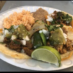 Plate setup with carne asada, chicken, and al pastor tacos with home made salsas