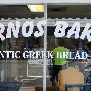 two people standing in front of a store window