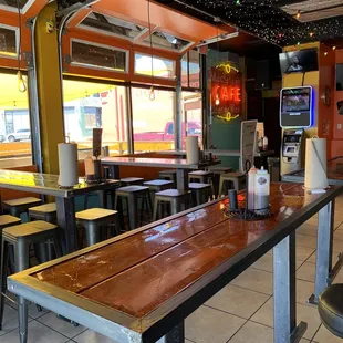 Interior dining room seating (open-air) with an outdoor patio outside to the left