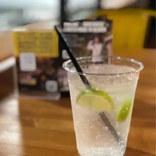 a glass of water with a lime slice in it