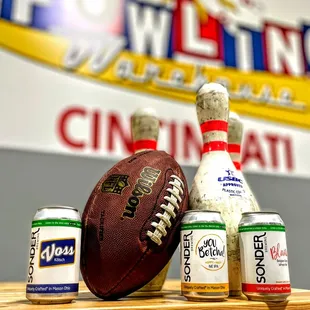 a football, two cans of beer, and a football