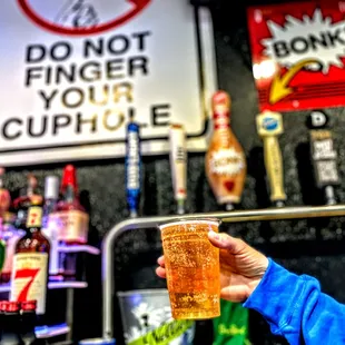 a person holding a pint of beer