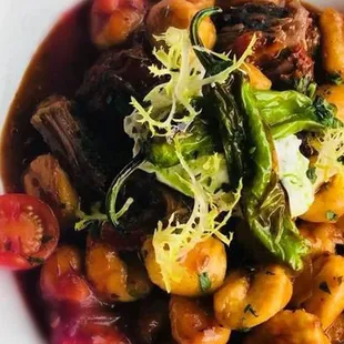 Braised short rib and gnocchi with heirloom tomato, shishito peppers, whipped ricotta