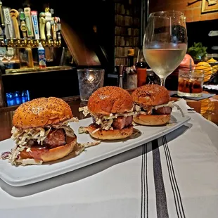 a plate of burgers and a glass of wine