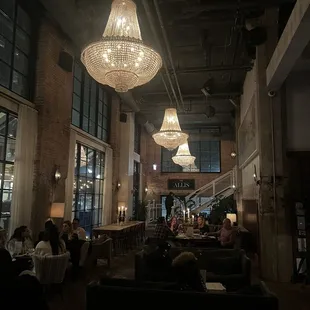 people sitting at tables and chandeliers