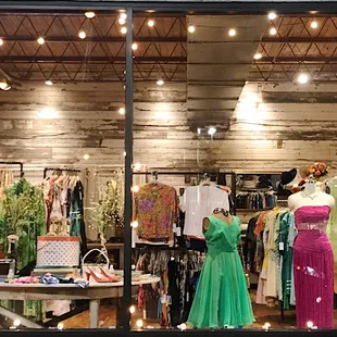 lit-up storefront at night featuring 60s dresses and an 80s pink strapless mary mcfadden!