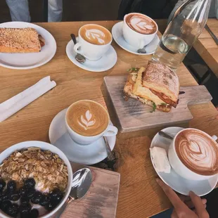 Yogurt with granola and berries, famous egg sandwich, ham and Swiss croissant, hot chocolate and cappuccino.