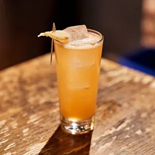 a glass of orange juice on a wooden table