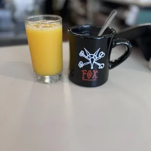 A very cool coffee cup, and some orange juice.