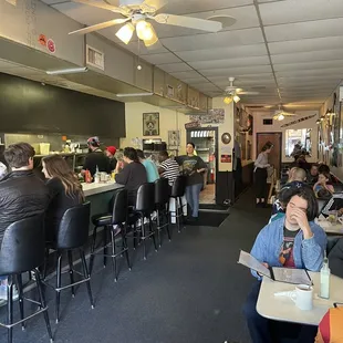 people sitting at tables in a restaurant