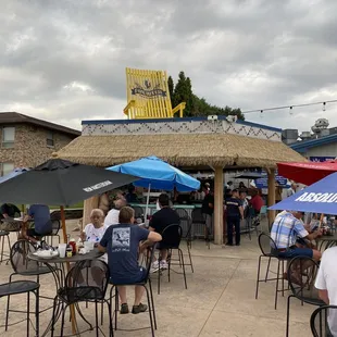 people sitting at tables under umbrellas