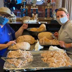 a woman and a man in masks preparing food