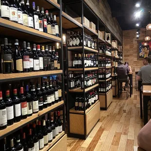 people sitting at tables in a wine shop