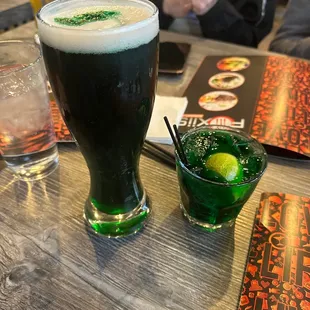a dark beer and a green drink