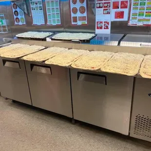 a counter with pizzas on it