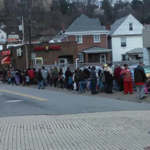 a line of people waiting to cross the street