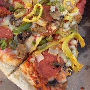 a slice of pizza with pepperoni, mushrooms, and peppers