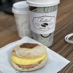 a breakfast sandwich and a cup of coffee