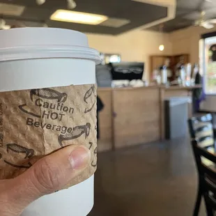 a hand holding a cup of coffee