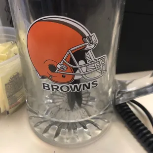 a glass mug with a football helmet on it