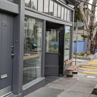 a bench on the sidewalk in front of a building
