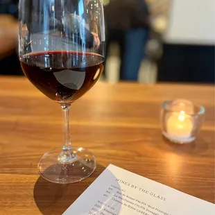 a glass of red wine on a table