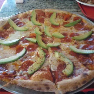 Large pepperoni and avocado pizza.