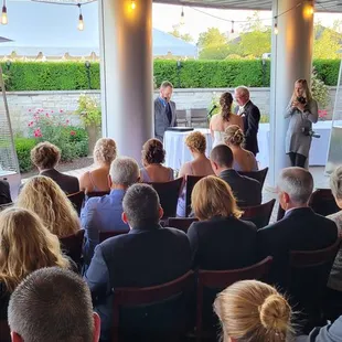 Outdoor ceremony yet under the protection of a roof.