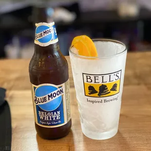 a glass of blue moon and a bottle of blue moon