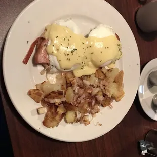 Eggs Benedict with home fries with added onion.