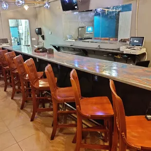 a long bar with wooden chairs