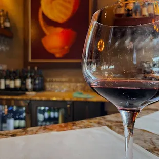 a glass of wine on a bar