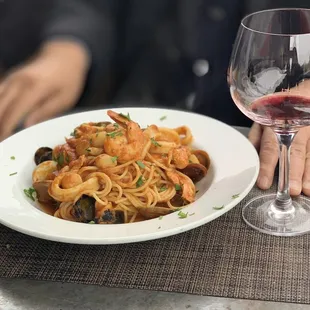 a plate of pasta and a glass of wine