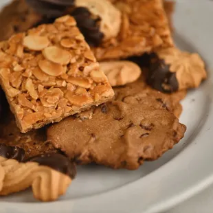 A plate of almond florentine bars, chocolate butter cookies, and plain butter cookies