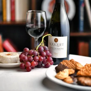 Red grapes, brie cheese, Cotes Du Rhone, and a plate of assorted cookies